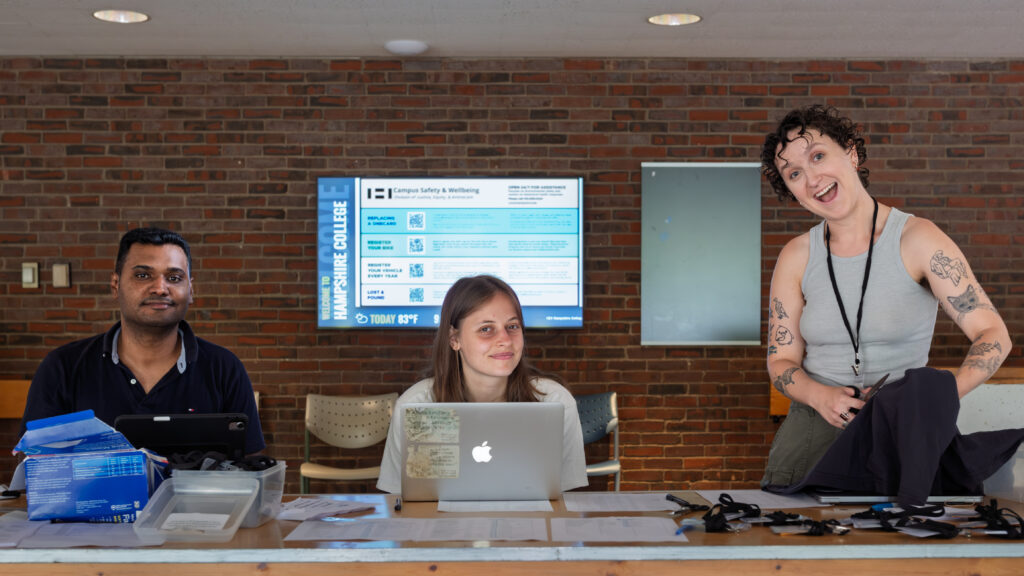 Summer Institute facilitators smiling at a check-in table