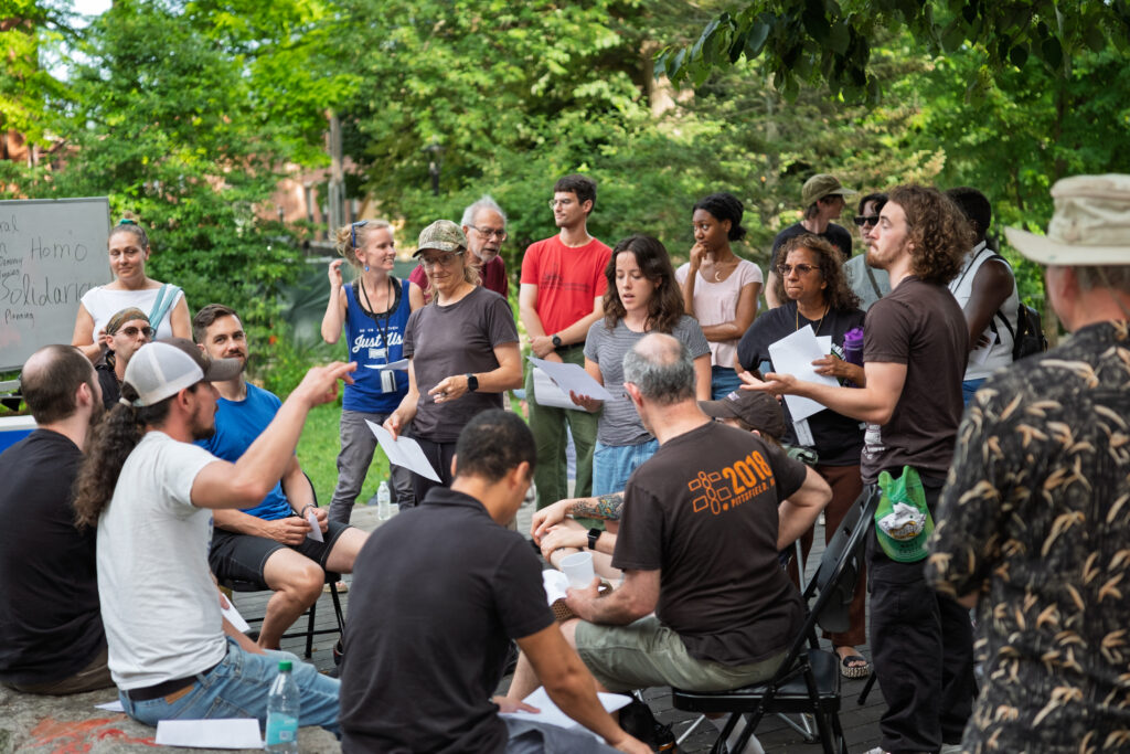 Participants discuss the approaches and ideas of past revolutionaries in a park