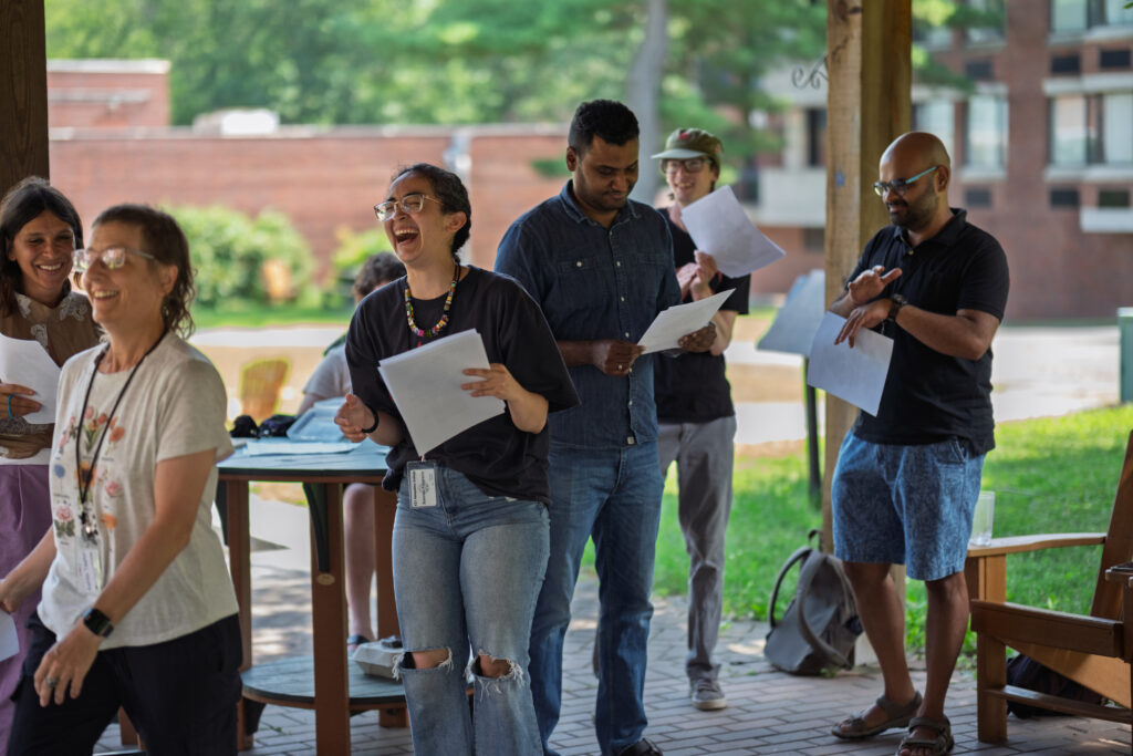 A Summer Institute facilitator laughing with some participants during an outdoor activity at the Summer Institute